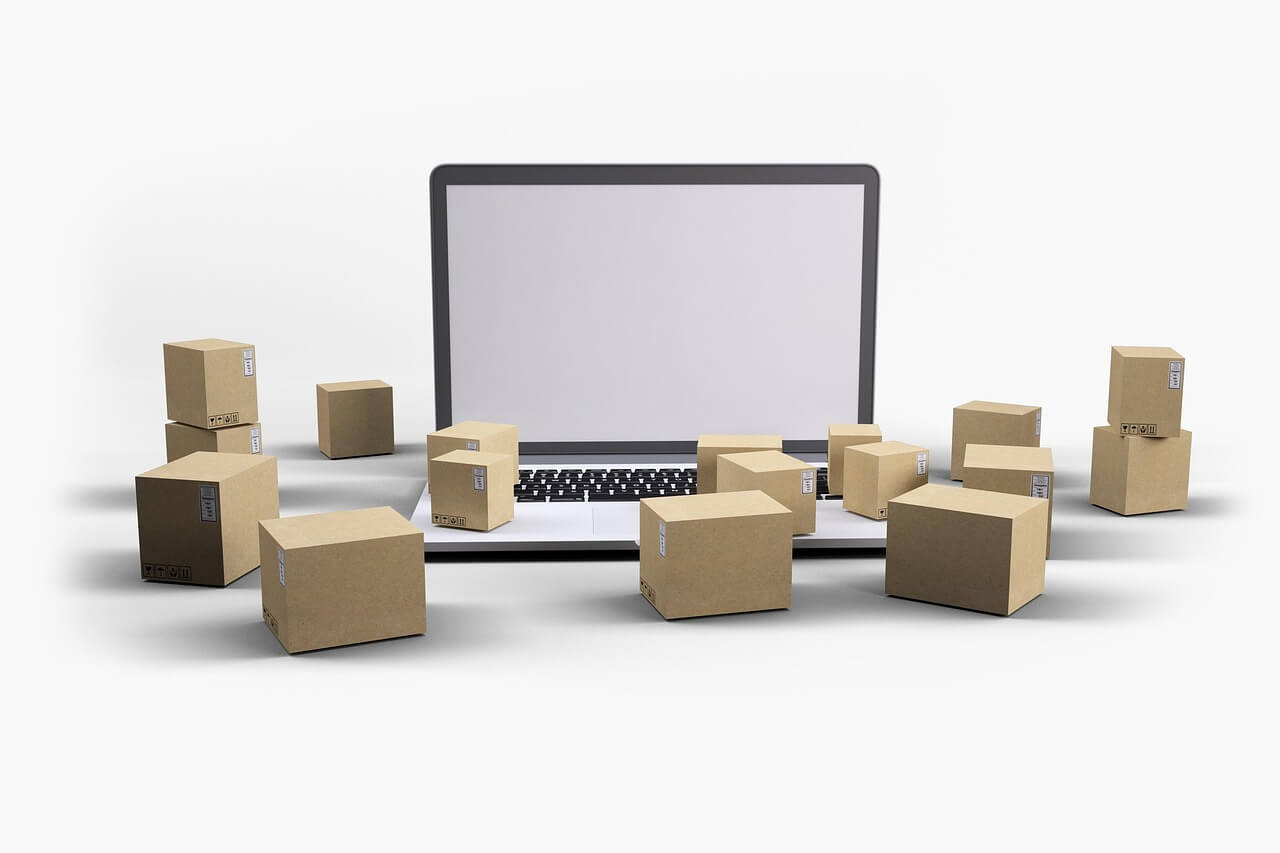 Laptop surrounded by boxes of packaging ready for delivery