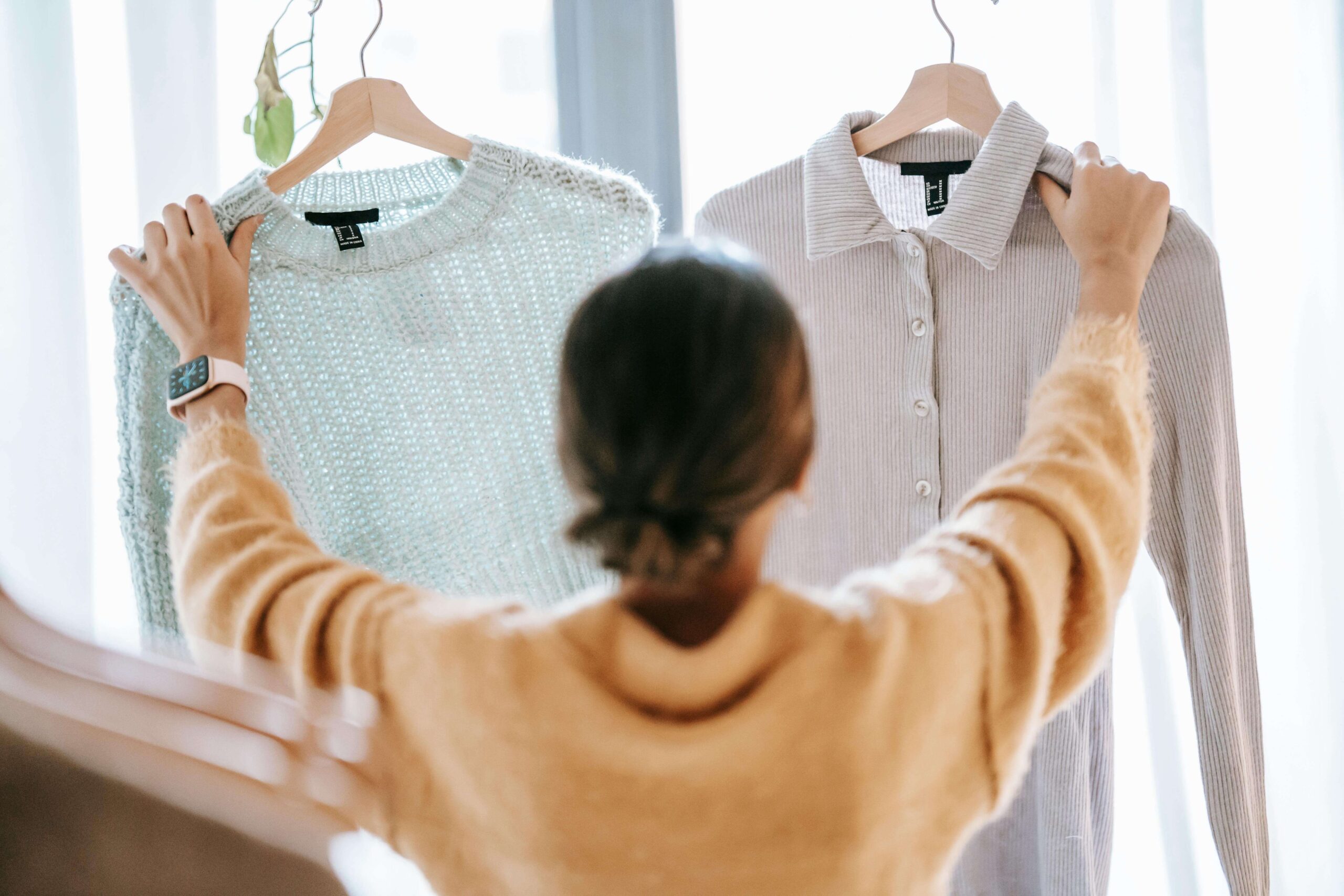 Woman choosing between two different shirts