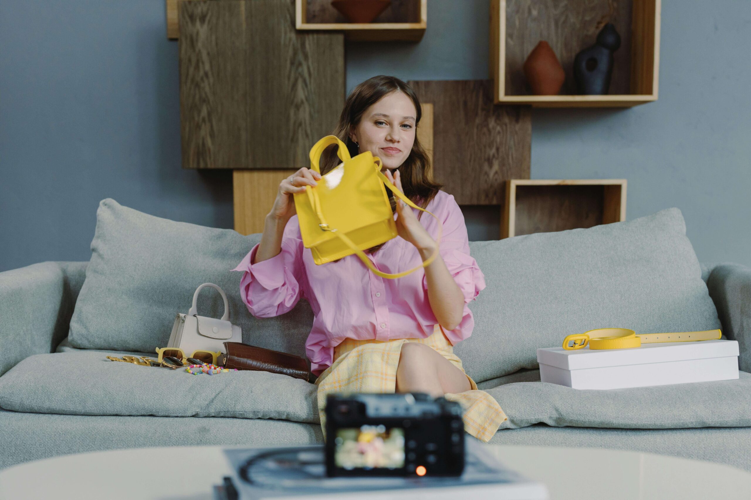 Female online seller recording a video of her selling a yellow bag