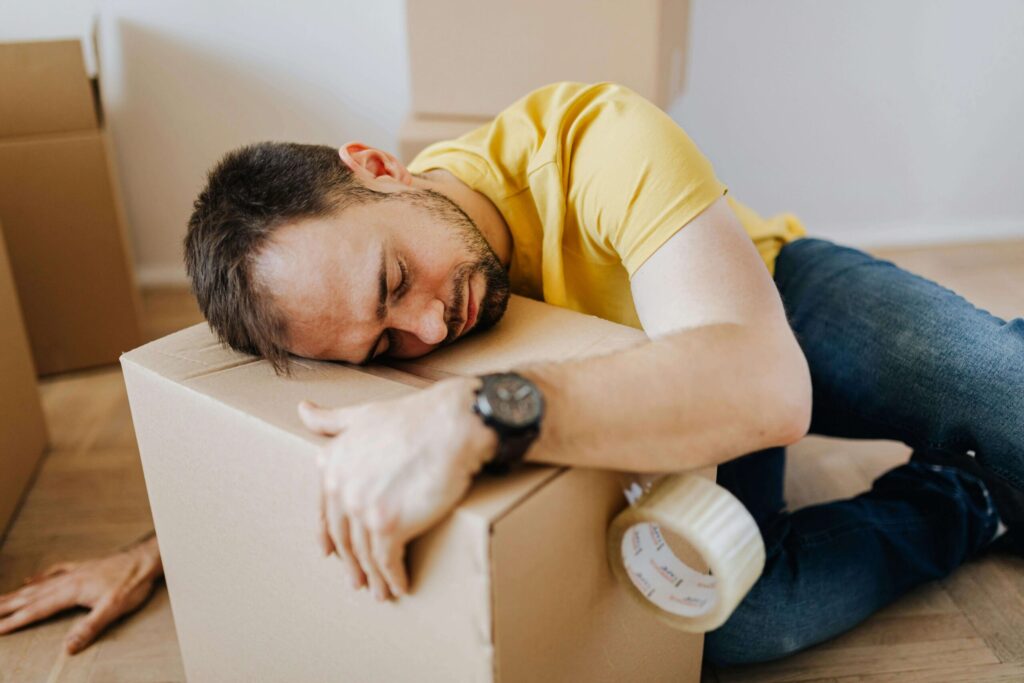 online seller sleeping on top of a box due to exhaustion