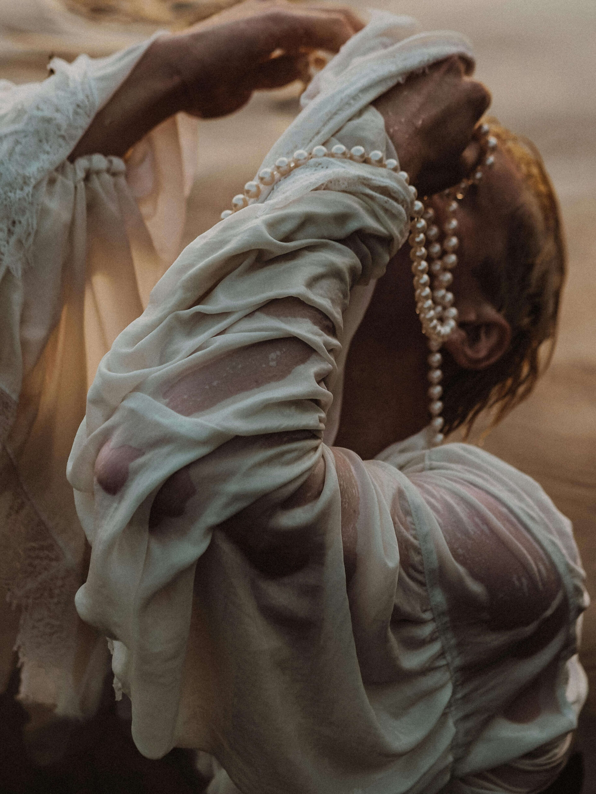 Woman soaked and wearing a string of pearls