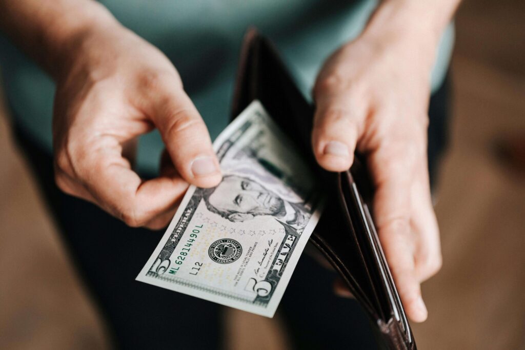 man taking out a dollar bill from his wallet