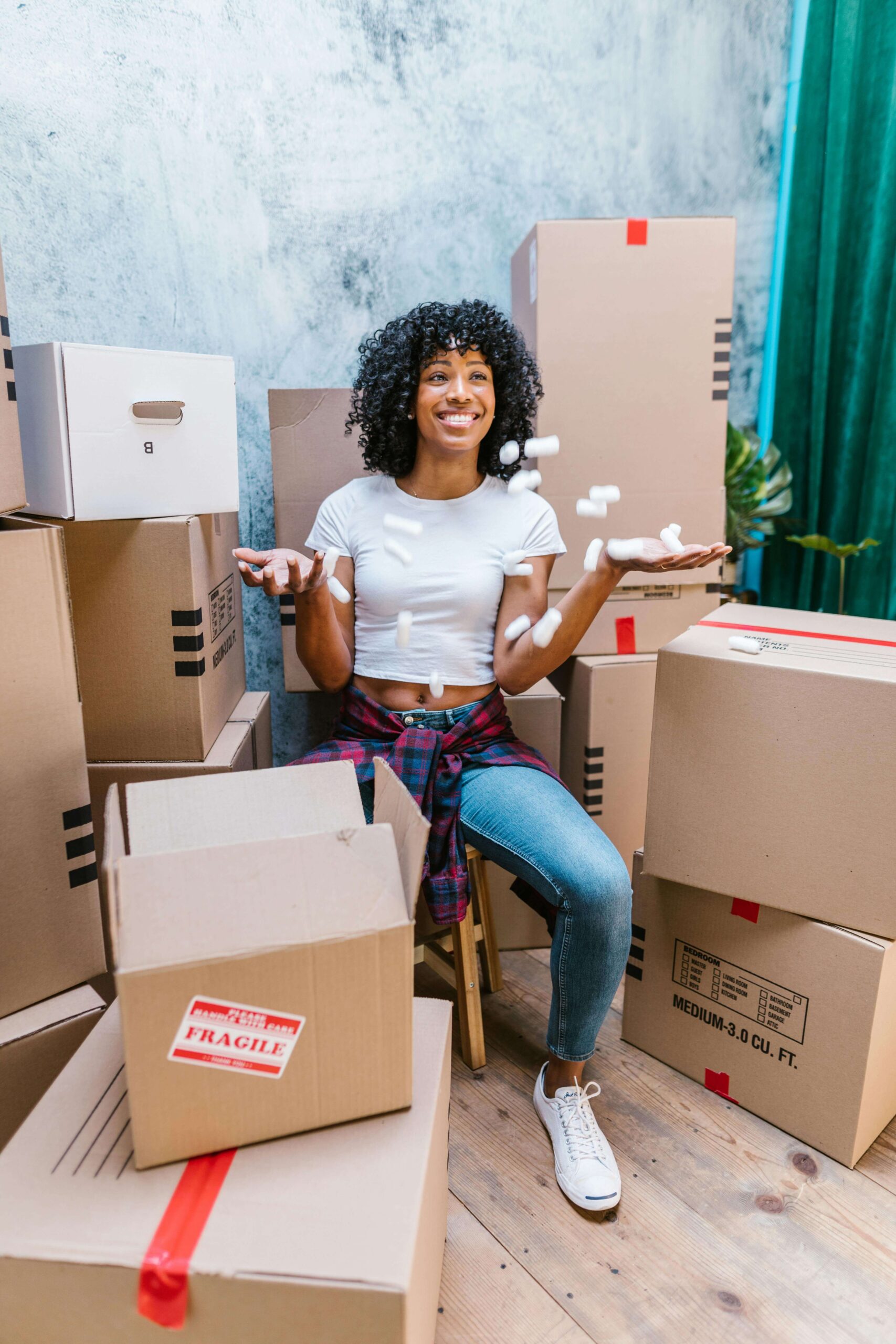 online seller surrounded by boxes of products while trying to catch objects 