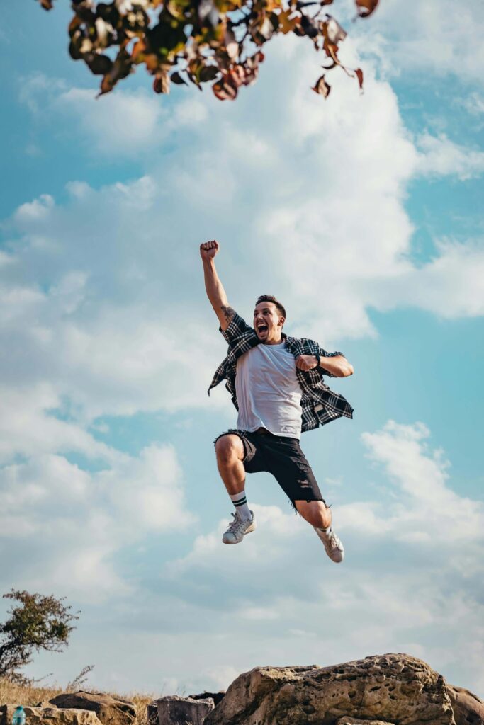 man jumping high as he experiences financial and creative freedom