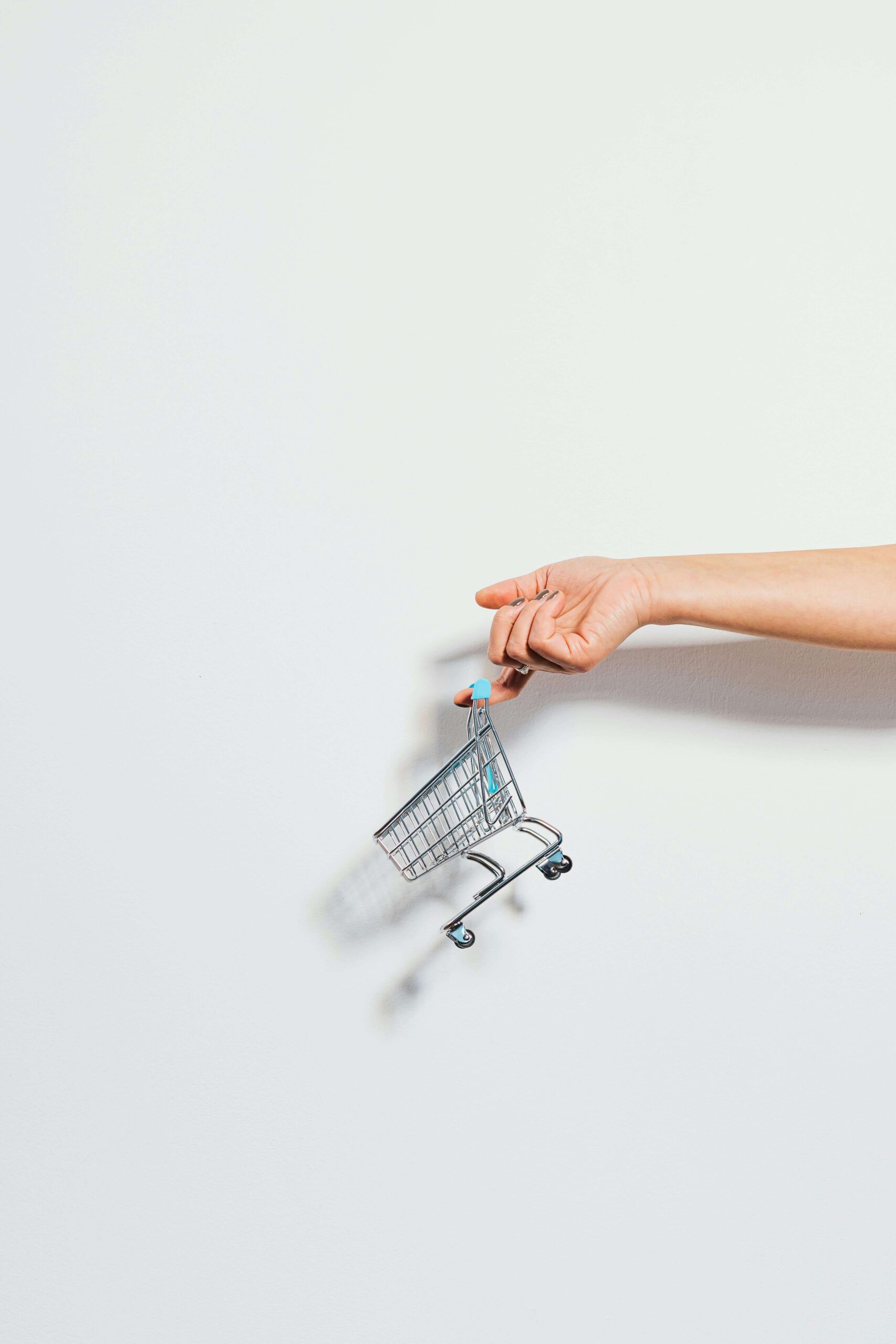 online shopping hand holding a small shopping cart